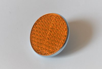 Odblask pomarańczowy, ocynkowana ramka, ze śrubką, 57 mm, plastik, Jawa, CZ